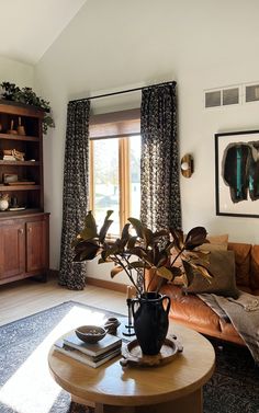 a living room with a couch, coffee table and bookshelf in front of a window