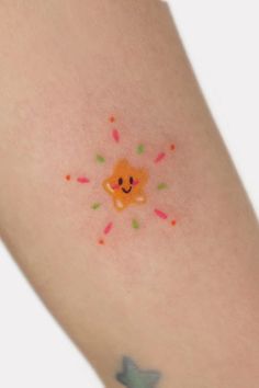 a small tattoo on the arm of a woman with sprinkles and a bear