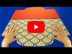 two hands holding up a piece of fabric with the video below it that shows how to make an ornament