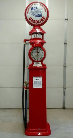 an old fashioned red gas pump with a clock on it's front and side