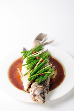 a white plate topped with fish covered in sauce