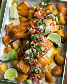 fish and potatoes on a plate with lime wedges