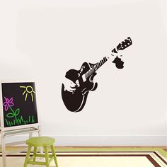 a guitar wall sticker in a room with a chair and easel next to it