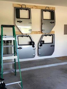 three different types of doors are hanging on the wall in a garage with ladders