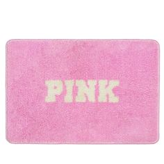 pink bath mat with the word pink printed in white on it's front side