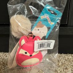 an animal keychain with a red fox on it's head and a white pom - pom in its pouch