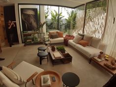 a living room filled with lots of furniture and plants on top of it's walls