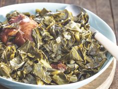 a bowl filled with collard greens and meat