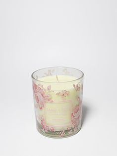 a glass candle with pink flowers on it