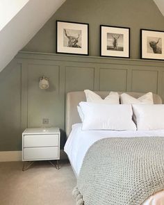 a bed sitting under two framed pictures in a bedroom