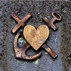 two crosses and a heart with an anchor on the side of a building in front of it