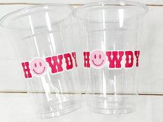 two plastic cups with stickers on them that say howdy and smiley face in red