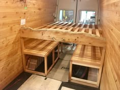 the inside of a small camper with wood walls and wooden slats on the floor