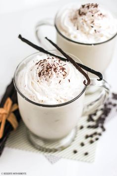 two mugs filled with whipped cream and chocolate