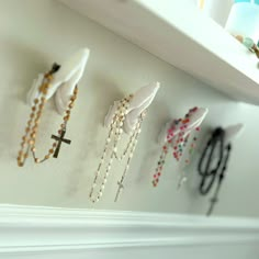 a white shelf topped with lots of necklaces on top of it's sides