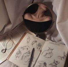 an open book with drawings on it next to a magnifying glass and pen