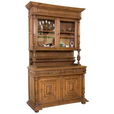 an old wooden china cabinet with glass doors on the top and bottom shelf, in front of a white background