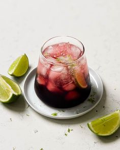 a drink with ice and limes on a plate