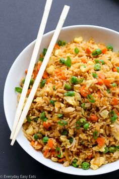 rice and vegetables in a bowl with chopsticks