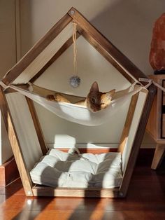 a cat laying in a hammock bed on the floor