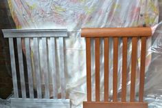 two wooden chairs sitting next to each other in front of a wall covered with plastic