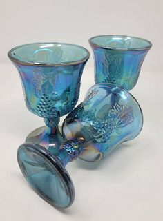 two blue glass vases sitting next to each other