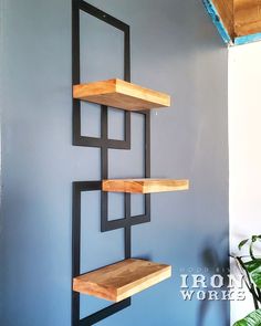 some shelves are hanging on the wall in a room with blue walls and a potted plant