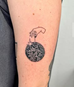 a person's arm with a small tattoo on it