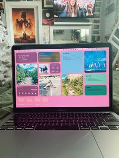 an open laptop computer sitting on top of a table next to a christmas tree and pictures