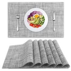 the placemat is next to a plate with vegetables on it and silver cutlers