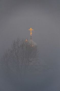 a cross on top of a church in the fog