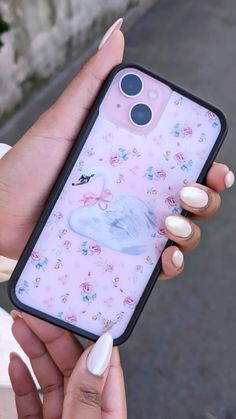 a woman holding up her phone case with an image of a swan on the back