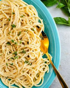 a blue plate topped with pasta and parsley