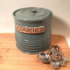 there is a cookie tin with spoons next to it