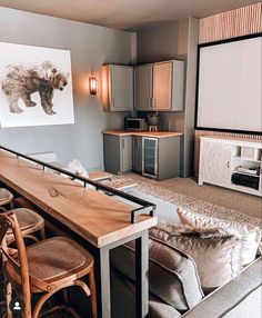 a living room filled with furniture next to a kitchen