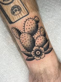 a man's arm with a tattoo on it that has a cactus and money