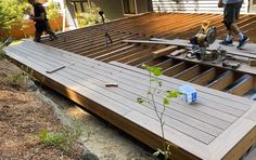 two men are working on a wooden deck