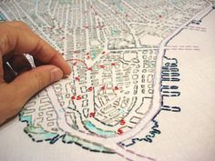 a person is using a marker to draw a city map on a piece of paper