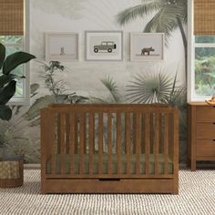 a baby's room with a crib, dresser and pictures on the wall