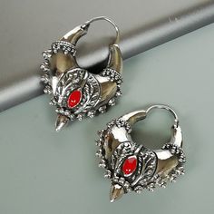 Tibetan style sterling silver ethnic hoops with tiny red stones. Dimensions: 25 x 37 mm Weight: 19.8 gm. Drop length: 10 mm Price is for ONE PAIR. These earrings are made of 925 hypoallergenic sterling silver. Most of my pieces come with a 925 stamp. Can be packaged in a gift box. I can include a personal message from you if needed You are welcome to contact me at... bhavnakwintra1956@gmail.com For more beautiful pieces from my shop, please browse 👇 TOE RINGS: https://www.etsy.com/your/shops/Th Red Round Earrings For Festival, Bohemian Red Metal Jewelry, Silver Hoop Jewelry For Festival, Handmade Gothic Hoop Jewelry, Red Metal Jewelry With Oxidized Finish, Red Oxidized Metal Jewelry, Gothic Silver Hoop Earrings, Small Hoop Red Metal Jewelry, Red Small Hoop Metal Jewelry