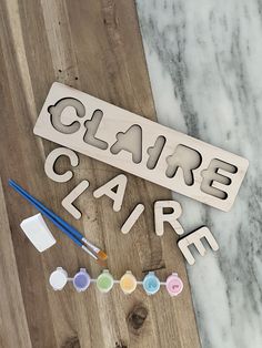 the word clarie is made out of wooden letters and paintbrushes on a table