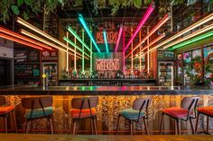 the bar is decorated with neon lights and chairs