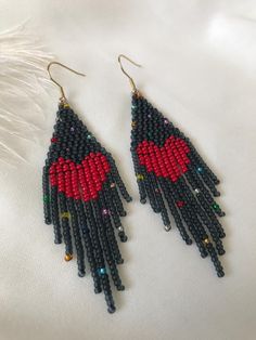 two pairs of beaded earrings with red and black beads hanging from the ends of them