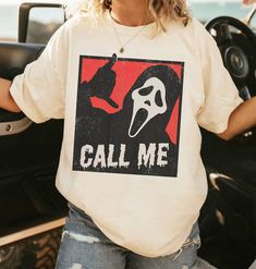 a woman wearing a t - shirt that says call me with a mask on it