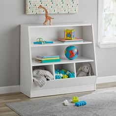 a white book shelf with toys on top of it in a child's room