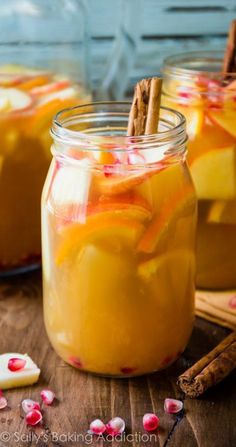 two mason jars filled with apple cider and cinnamon sticks