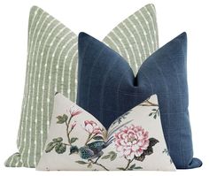 two blue and green pillows with flowers on them, one in the shape of a bird