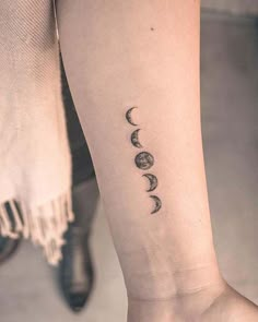 a woman's foot with three phases of the moon tattoo on it