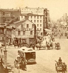 an old photo of a city street with horse drawn carriages