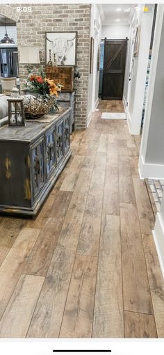 a large wooden floor in a house with brick walls and white trim on the wall